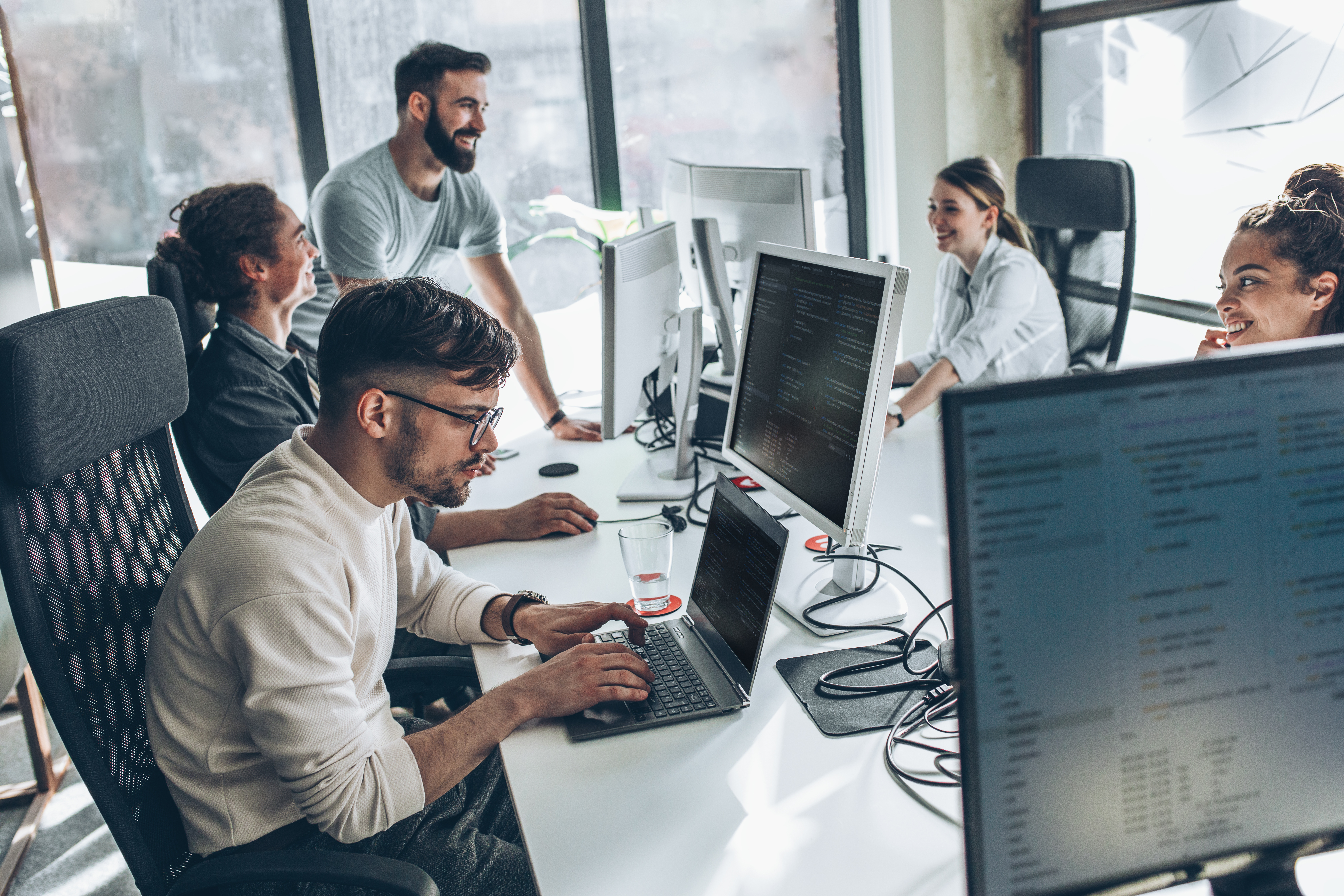 People around a table looking at their computers